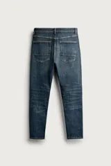 Jeans skinny fit de color azul, con efecto lavado y detalles de roturas en las piernas. Diseño de cinco bolsillos, tiro medio y cierre frontal con cremallera y botón.