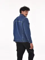 Campera de jean azul de hombre, con cuello camisero, cierre frontal de botones y bolsillos a la altura del pecho.