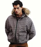 Campera masculina de corte regular con estampado a cuadros, cierre frontal con cremallera y capucha fija con borde de pelo sintético. Cuenta con bolsillos frontales con solapa y cierre de botón a presión.