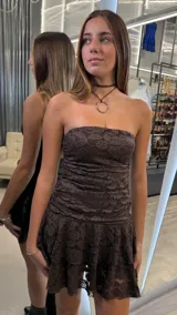 Vestido corto strapless de encaje color marrón oscuro, con diseño fruncido en el cuerpo y falda con volados en capas.
