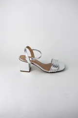 Sandalias de fiesta metalizadas color celeste, con taco cuadrado de 4 cm, tiras delanteras acolchadas y tira ajustable al tobillo con hebilla dorada.