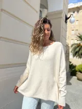Sweater de punto en color crudo, con diseño oversize, cuello redondo y mangas largas. Presenta una textura suave y caída holgada.