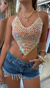 Top de hilo color crudo, tejido al crochet, con lentejuelas iridiscentes.