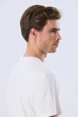 Remera azul marino de manga corta con cuello redondo, confeccionada en mezcla de algodón y poliéster. Presenta un diseño en el frente que combina estampa y bordado con la leyenda "Legacy Brand 1972" en tonos rosado, verde y marrón.