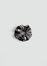 Colita de pelo scrunchie gris de algodón, decorada con múltiples botones de nácar de distintos tamaños distribuidos por toda la superficie.