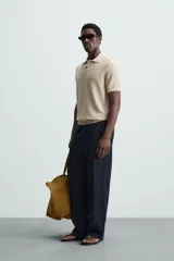 Polo de manga corta, corte regular fit, color verde oliva. Tejido de punto con textura acanalada vertical y cuello solapa con dos botones.