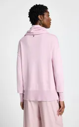 Polera de punto fino color rosa, con cuello holgado tipo cowl y mangas largas con puños ajustados.