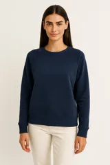 Sudadera negra de cuello redondo, manga larga tipo raglán y corte holgado.