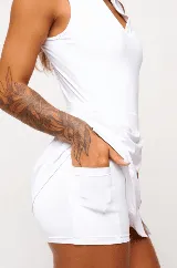 Vestido deportivo negro sin mangas, con escote en V y logo estampado en el pecho. Falda corta con short interno y bolsillos laterales. Incluye protección UV50+.