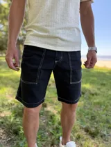 Bermuda de jean gris claro con efecto acid wash, bolsillos delanteros aplicados y costuras destacadas.