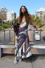 Vestido largo sin mangas de corte evasé con estampado abstracto en tonos bordó, beige y rosado, escote en V y tirantes finos.