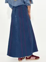 Pollera larga de jean azul con rayas verticales verdes.