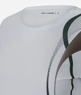 Remera deportiva de mujer Get Over, confeccionada en microfibra blanca con cuello redondo, manga corta y un diseño estampado de ondas en color verde y marrón en el lateral izquierdo.