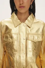 Campera de cuero negro al cuerpo, con cuello camisero, bolsillos de parche con solapa en el pecho y cierre frontal con broches a presión.