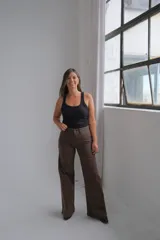 Pantalón tipo jean de corte recto y tiro medio, en color marrón chocolate, con bolsillos traseros clásicos y cierre frontal.