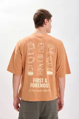 Camiseta color naranja con estampado de motivos relacionados al café, corte amplio y recto.