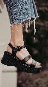 Sandalia de cuero marrón con plataforma corrida y taco alto texturizado. Posee tiras delanteras múltiples y una pulsera al tobillo con hebilla ajustable.