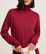 Vestido de punto negro, de manga larga y cuello alto, con corte recto y largo midi.