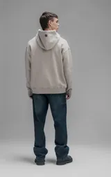 Hoodie oversize de color beige, confeccionado en frisa premium. Presenta capucha ajustable con cordones, bolsillo tipo canguro frontal y puños con aberturas para pulgares.