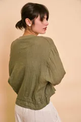 Campera bomber verde militar de lino, con cierre frontal, bolsillos laterales y detalles de cordones ajustables en el ruedo.