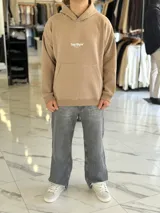 Canguro negro oversize con capucha y gran estampado blanco en la espalda con el texto "Top Style", "Dream big. Work hard. Make it real.", "SINCE 2021" y un código de barras.