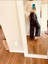 Pantalón cargo de cuero ovino negro con costuras blancas en contraste y corte suelto.