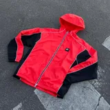 Campera deportiva Nike Air con capucha, diseño en color naranja con paneles laterales negros y detalles en blanco. Cuenta con cierre frontal completo y parche con logo en el pecho.