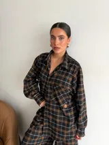 Pantalón de corte recto y holgado, confeccionado en tela de viyela con estampado de cuadros en tonos negro, gris y blanco. Presenta cintura elástica para mayor comodidad.