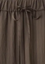 Pantalón de corte recto y pernera ancha, color verde militar con sutiles rayas verticales. Cuenta con cintura elástica con cordón ajustable y bolsillos laterales.