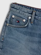 Shorts de jean de tiro alto, color celeste claro, con ruedo desflecado y logo de Tommy Hilfiger bordado en el bolsillo trasero.