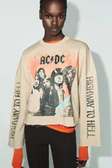 Sudadera beige de mezcla de algodón, con cuello redondo, manga larga y bajo deshilachado. Presenta un estampado frontal de la banda AC/DC con llamas naranjas y el texto "Highway to Hell" en las mangas.