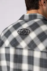 Camisa de manga corta de popelina cuadrillé en tonos marrón, blanco y gris, con diseño boxy fit, cuello camisero, cierre frontal de botones, bolsillo en el pecho con detalle bordado y dobladillo recto.
