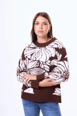 Buzo tejido de punto con diseño floral estampado en contraste, cuello redondo y terminaciones en rib. Presenta un calce holgado y mangas largas.