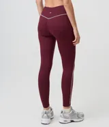 Pantalón legging deportivo Get Over de color bordó, confeccionado en microfibra elastizada con cintura alta y una línea vertical en contraste en el lateral.