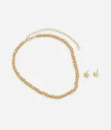 Conjunto de bisutería compuesto por un collar corto de cadena tipo entremedios metálicos y un par de aros pequeños con diseño de nudo entrelazado, ambos en acabado dorado.