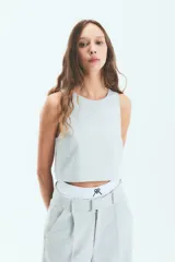 Pantalón de vestir estilo sastrero en color gris, confeccionado en crepe. Presenta un corte recto y holgado con tajo en la botamanga interna y bolsillos laterales.