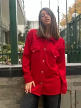 Camisa de estilo western color rojo, confeccionada en tejido de punto, con cuello clásico, cierre frontal de botones, dos bolsillos frontales con solapa y manga larga con puños.