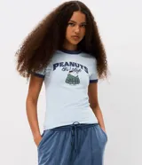 Remera de algodón color celeste con cuello y bordes de mangas en color azul marino. Presenta estampa frontal con el personaje Snoopy vestido con campera puffer y la inscripción Peanuts Ski Lodge.