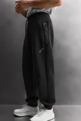 Pantalón jogger de entrenamiento regular fit confeccionado en tejido técnico compacto de algodón con elasticidad y efecto neopreno. Cuenta con cintura elástica ajustable con cordón, bolsillos frontales, un bolsillo lateral con cierre de cremallera y bajo acabado en puño.
