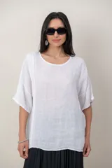 Blusa de lino color blanco, con escote redondo, mangas cortas holgadas y detalle vertical de alforzas en el lateral.