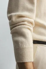 Jersey de punto relaxed fit confeccionado en mezcla de lana y fibra de alpaca, con textura ligera y efecto pelo. Presenta cuello redondo, manga larga y acabados en rib en puños y cintura.