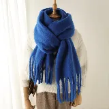 Bufanda de tejido suave y abrigado en color azul vibrante, con diseño de flecos largos en los extremos.