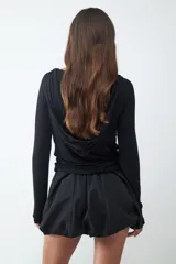 Minifalda de tiro bajo con silueta tipo globo, confeccionada en tejido técnico con cintura elástica oculta y bajo redondeado.