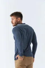 Chomba manga larga color beige con rayas horizontales blancas, cuello polo con borde azul marino y logo bordado en el pecho.