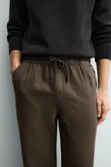 Pantalón de corte regular fit confeccionado en tejido mezcla de algodón, con cintura elástica ajustable mediante cordón, bolsillos laterales y bolsillos traseros de vivo.
