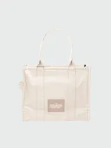 Bolso tipo tote de Marc Jacobs, confeccionado en lona resistente de color negro. Presenta el nombre del modelo estampado en blanco en la parte frontal y el logo de la marca debajo. Cuenta con doble asa superior para llevar al hombro o en la mano.