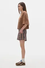 Remera color crudo de algodón lavado, corte cropped y mangas cortas. Presenta un pequeño bordado con las iniciales "PS" en el pecho.