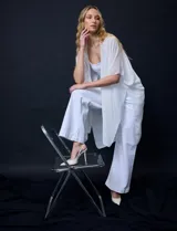 Kimono de gasa color blanco, con diseño abierto y mangas amplias. Presenta detalles de apliques brillantes a lo largo de la abertura frontal.