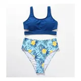 Bikini de dos piezas modelo Brenda, compuesto por un top deportivo liso color amarillo y una bombacha de tiro alto con estampado tropical de flores rojas y hojas verdes sobre fondo amarillo.