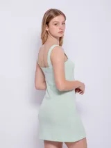 Vestido corto sin mangas de tela texturada con tirantes anchos y estampado a cuadros en blanco y negro.